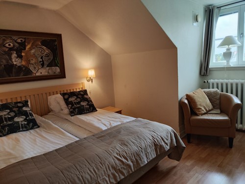 Boende rummet med säng och fåtölj